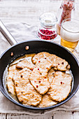 Schnitzel in beer sauce with red peppercorns