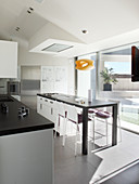 Moderne Designerküche mit Kochinsel und Fensterfront