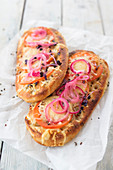 Focaccia with tomatoes, vegan grated cheese and pickled onions (Italy)