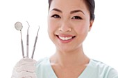 Female dentist holding dental instruments