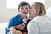 Boy and nurse listening to stethoscope