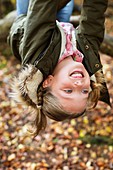 Young girl hanging upside down