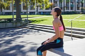 Young woman sitting on wall