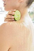 Woman squeezing fresh lime juice down back
