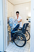 Nurse aiding an elderly woman to the toilet