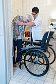 Nurse aiding an elderly woman to the toilet