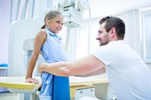 Doctor preparing girl for x-ray in hospital