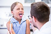 Doctor taking a swab from a girl's mouth