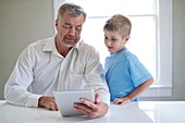 Grandfather and grandson using tablet
