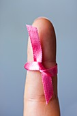 Woman with pink ribbon tied to finger