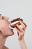 Woman eating chocolate doughnut