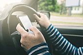 Woman driving car and using mobile phone