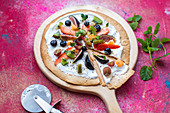Fruit Pizza made from a toasted Tortilla wrap base, with natural yogurt, fresh fruit toppings, chia seeds and mint to garnish