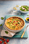 Spring quiche with cheese, spinach, tomatoes, courgette and spring onion