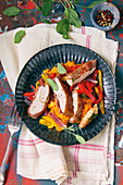 Saltimbocca on a bed of colourful peppers