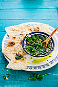 Crisp flatbread with Zhug sauce (spicy sauce with coriander and parsley, Yemen)