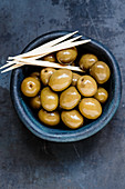 Preserved green olives with toothpicks