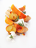 Butternut squash slices with halved onions and feta cheese