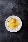 Flüssiger Honig mit Honigwaben in weißem Teller