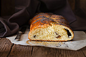 Sweet bread with poppyseeds, sliced on a piece of baking paper
