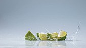 Lime pieces falling in water, slow motion