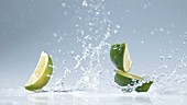 Lime pieces falling in water, slow motion
