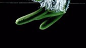 Courgettes falling in water, slow motion