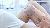 Physiotherapist measuring leg movement