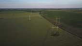 Drone flying over pylons in field