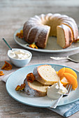 Lemon wreath cake served with cream and apricot compote (Italy)