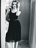 A young woman wearing a black dress (black-and-white shot)