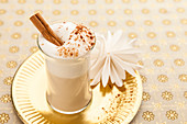A wintery latte with milk foam and cinnamon in a glass cup
