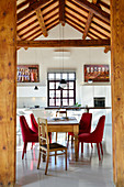 View through wooden columns into dining area and open-plan kitchen