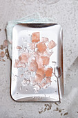 Rosé wine ice cubes and ice splinters on a silver tray