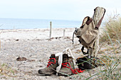 Walking boots, binoculars and rucksack on beach