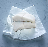 Raw halibut steaks on paper