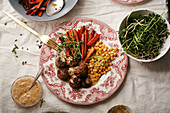 Swedish meatballs garnished with bechamel sauce and micro-greens with chickpeas and caramelized carrots