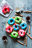 Donuts with marbled icing on a plate and coffee mugs on the table