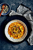 Carrot, cumin and cashew nut dip with charcoal crackers and sesame seeds