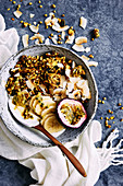Healthy breakfast bowl of yogurt, turmeric glutin free muesli clusters, toasted coconut, fresh fruit and honey comb