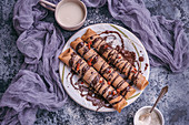 Spelt crepes with dark chocolate drizzle served on a plate
