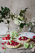 Cherry and raspberry tarts on a wooden rustic table
