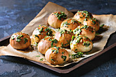 Traditional ukrainian homemade garlic buns pampushki for borscht soup with oil and coriander on old oven tray with baking paper