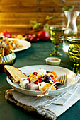 In Olivenöl und Wein geröstetes Gemüse mit Feta serviert mit Brot