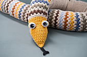 A crocheted snake with eyes