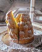 A Bundt cake with candied fruit and icing sugar with a pearl ring hidden in the middle