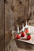 Vier Äpfel als Kerzenhalter für Advent