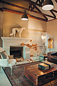 Living room in shades of brown with exposed roof structure and open fireplace