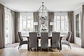 Grey upholstered chairs around wooden table in elegant dining room