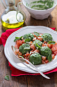 Spinach gnocchi with raw tomatoes, cheese and basil